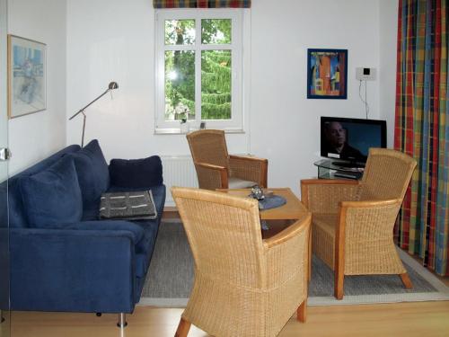 ein Wohnzimmer mit einem blauen Sofa und Stühlen in der Unterkunft Apartment Stubbenkammer by Interhome in Breege