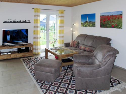 a living room with a couch and a tv at Holiday Home Rügenperle by Interhome in Altefähr