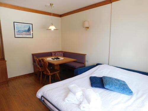 a bedroom with a bed and a small table at Ski Residence in San Martino di Castrozza