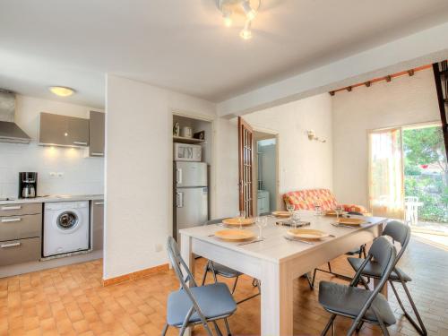 - une cuisine et une salle à manger avec une table et des chaises dans l'établissement Holiday Home Les Villas de l'Aygual by Interhome, à Saint Cyprien Plage