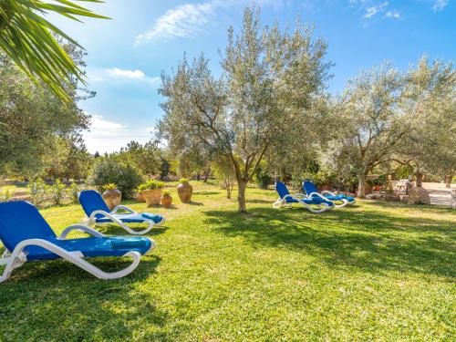 a group of blue chairs sitting in the grass at Holiday Home Son Catlar - INC125 by Interhome in Inca