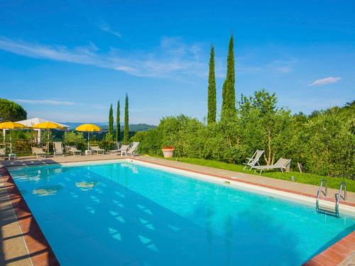 a large swimming pool with blue water at Apartment Lucia by Interhome in Podere Panzano