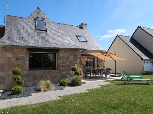 Cette maison en pierre dispose d'une terrasse et d'une table. dans l'établissement Holiday Home Les Camélias - PGC106 by Interhome, à Perros-Guirec