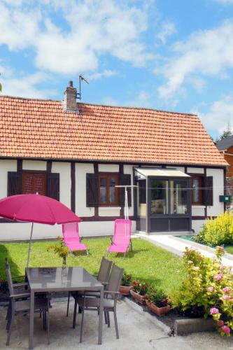 a house with a table and chairs and an umbrella at Holiday Home La Mesnièroise by Interhome in Mesnières-en-Bray