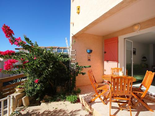 a patio with a table and chairs and flowers at Holiday Home Mer Indigo-3 by Interhome in Saint Pierre La Mer