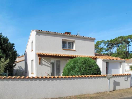a white house behind a white fence at Holiday Home Les Etrilles by Interhome in La Tranche-sur-Mer