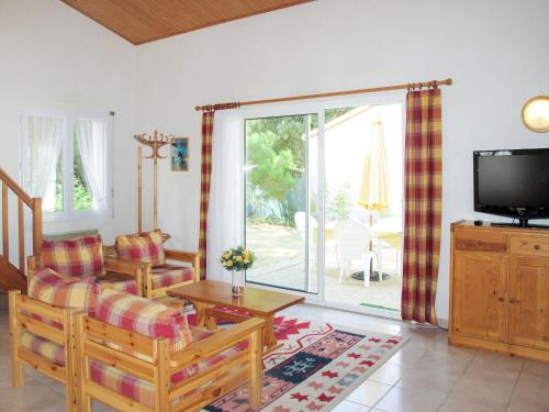 ein Wohnzimmer mit einem Sofa und einem TV in der Unterkunft Holiday Home Les Etrilles by Interhome in La Tranche-sur-Mer