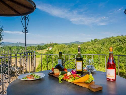 a table with two bottles of wine and a plate of food at Apartment Simone by Interhome in Podere Panzano