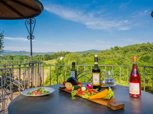 Podere PanzanoにあるApartment Arco by Interhomeのワイン2本と食器一皿付きのテーブル