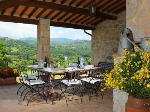einen Tisch und Stühle auf einer Terrasse mit Aussicht in der Unterkunft Holiday Home Podere dei Venti by Interhome in Leccio