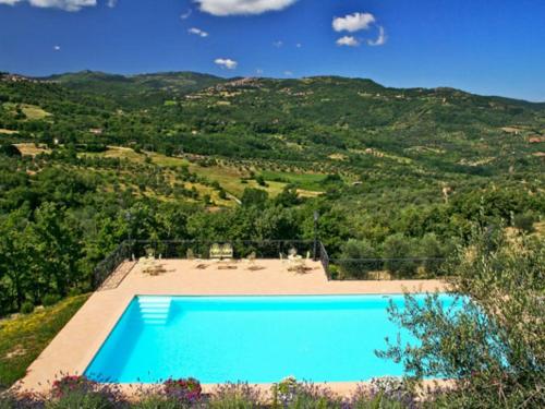 an image of a swimming pool with mountains in the background at Holiday Home Podere dei Venti by Interhome in Leccio