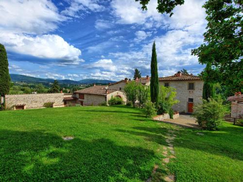 a green yard with a house and trees in the background at Apartment Il Mandorlato by Interhome in Grassina