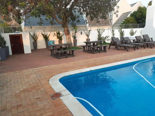 a patio with picnic tables and a swimming pool at The Holy Hill Royal Alfred Marina in Port Alfred