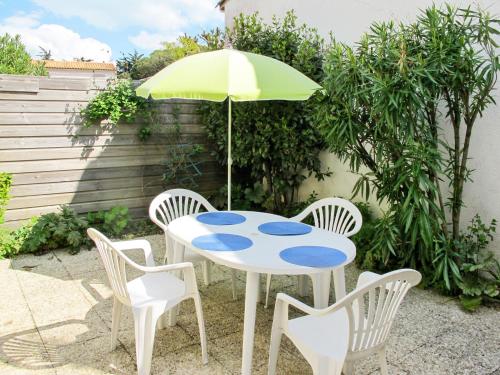 une table avec un parasol vert et quatre chaises dans l'établissement Holiday Home La Touche-2 by Interhome, à La Flotte