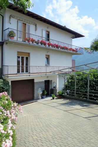 a white house with a balcony and a driveway at Apartment Bellavista by Interhome in Porlezza