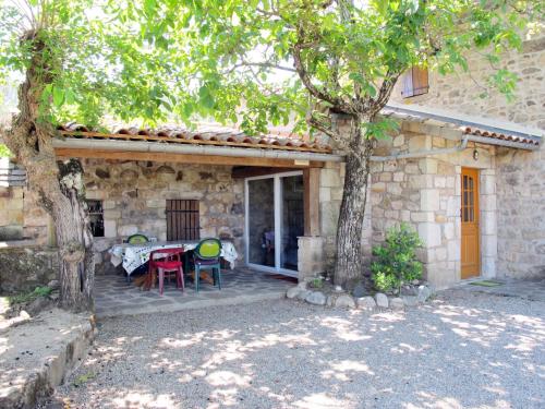 a patio with a table and chairs in front of a house at Holiday Home Malbosc by Interhome in Saint-Genest-de-Bauzon
