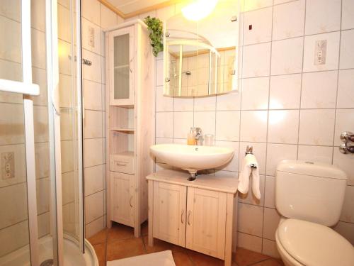 ein Badezimmer mit einem Waschbecken, einem WC und einem Spiegel in der Unterkunft Apartment Am Birkenhain-28 by Interhome in Seefeld in Tirol