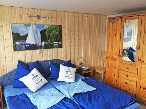 sypialnia z łóżkiem z niebieską pościelą i poduszkami w obiekcie Chalet Güstrower Chaussee by Interhome w mieście Krakow am See