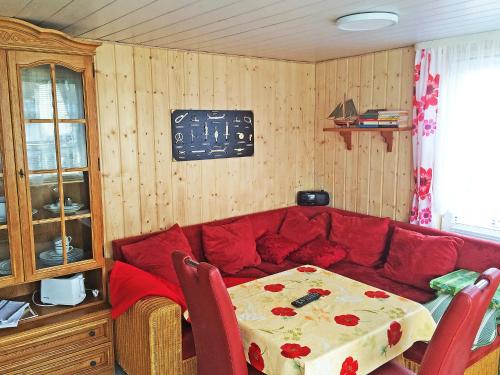 a living room with a red couch and a table at Chalet Güstrower Chaussee by Interhome in Krakow am See