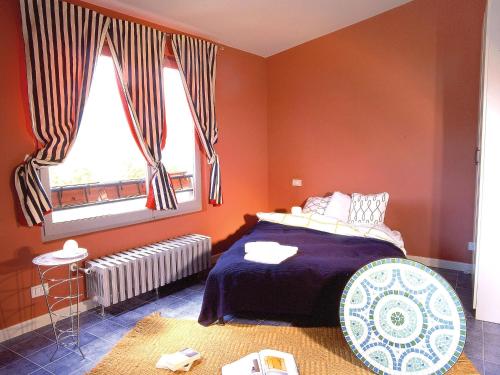 una camera da letto con pareti arancioni, un letto e una finestra di Studio Casa sul lago by Interhome a Orta San Giulio