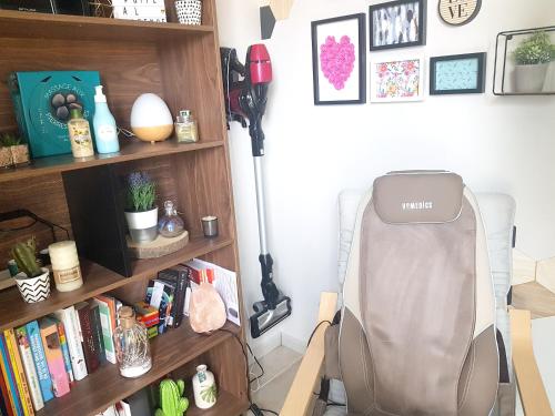 a room with a chair in front of a book shelf at Charmante Maison avec jardin à Mornas in Mornas