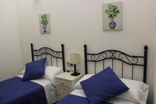 Duas camas com almofadas azuis num quarto em A Nosa Casa em Belesar