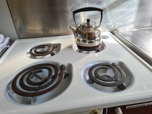 a stove top with a tea kettle on top of it at Risberg Herrgård in Hagfors