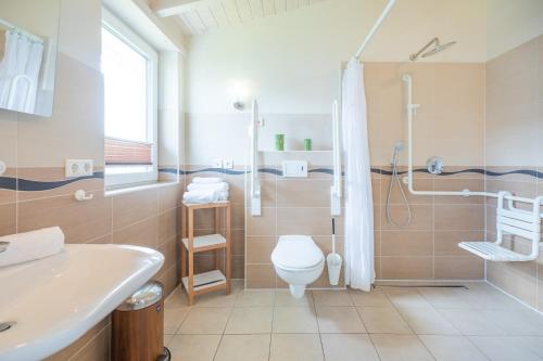 e bagno con servizi igienici, doccia e lavandino. di Ferienhaus Herzmuschel a Dagebüll