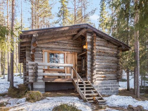 a log cabin with a staircase in the woods at Holiday Home Retkietappi honkapirtti by Interhome in Juuma