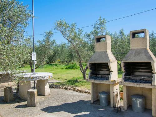 two stone ovens sitting next to a table at Apartment Le Macine-4 by Interhome in Cecina