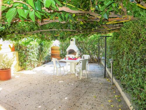 una mesa y sillas sentadas bajo una pérgola en Apartment Les Terrasses de la Méditerranée-2 by Interhome, en Saint Pierre La Mer