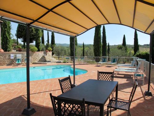 um pátio com uma mesa e cadeiras e uma piscina em Villa Le Gallozzole by Interhome em Quercegrossa