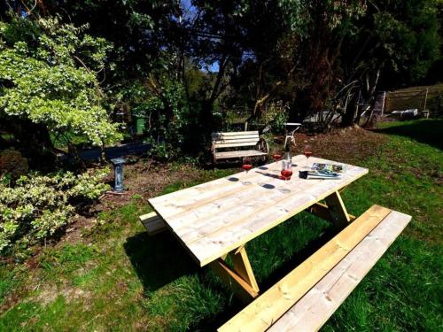 a wooden picnic table and bench in a yard at Holiday Home Arthog by Interhome in Arthog