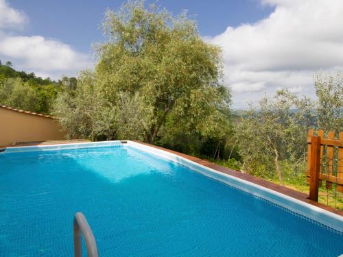 チヴィテッラ・イン・ヴァル・ディ・キアーナにあるHoliday Home Il Borgo di Gebbia by Interhomeの青いスイミングプール(木々の景色を望む)