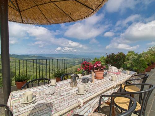 una mesa con sillas y una sombrilla en el patio en Holiday Home Il Borgo di Gebbia by Interhome, en Civitella in Val di Chiana