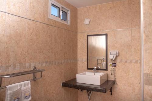 a bathroom with a sink and a mirror at Hotel Altomar in Catia La Mar