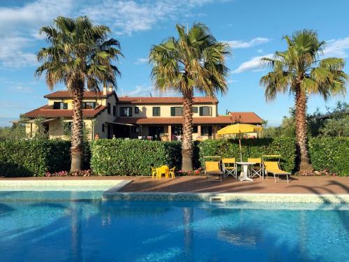 une maison avec des palmiers et une piscine dans l'établissement Apartment Le Macine-3 by Interhome, à Cecina