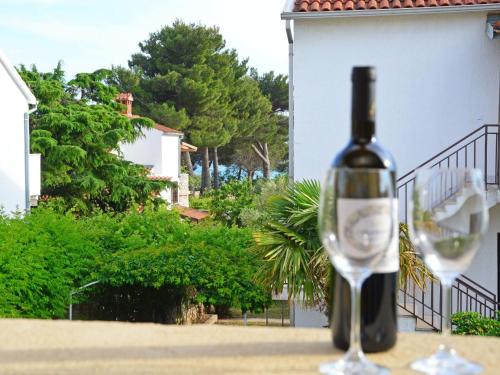 una bottiglia di vino seduta accanto a un bicchiere di vino di Apartment Lastavica-2 by Interhome a Jadrija