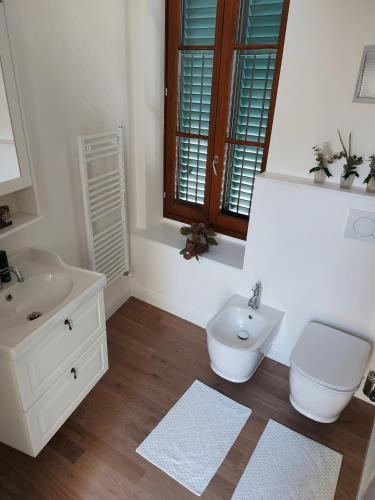 a white bathroom with a toilet and a sink at Castle Rooms in Prato