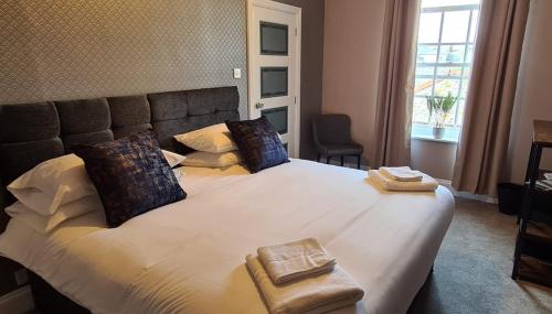 a bedroom with a large white bed with two pillows at Bold Arms in Beaumaris