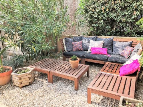 un patio avec un canapé et deux bancs en bois dans l'établissement Holiday Home Santa Marina-7 by Interhome, à Saint Pierre La Mer