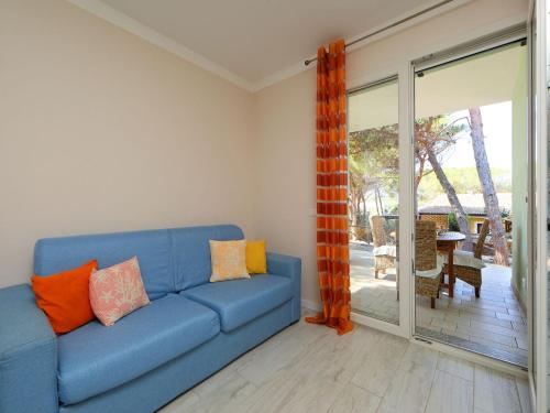 a blue couch in a living room with a sliding glass door at Holiday Home San Pietro Blue by Interhome in Codaruina