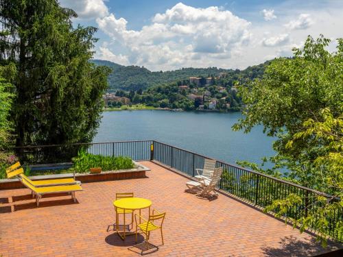 een patio met een tafel en stoelen en uitzicht op een meer bij Villa Bice by Interhome in Laveno-Mombello
