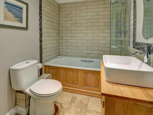 a bathroom with a toilet and a tub and a sink at Holiday Home Valentines Cottage by Interhome in Braunton