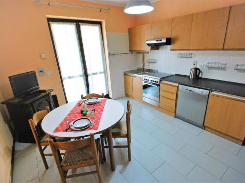 una cucina con tavolo e sedie in una stanza di Apartment La Remise-2 by Interhome ad Aosta