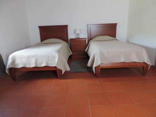 two beds sitting next to each other in a room at Quinta das figueiras in Velas