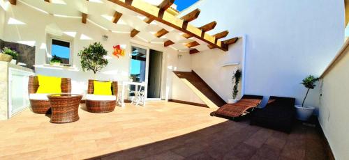 a living room with wicker chairs and a staircase at SCRUSCIU HOME in Terrasini