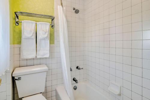 a bathroom with a toilet and a bath tub with towels at Atlantic Hotel, Inc in Ocean City
