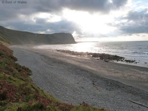 a beach with rocks and the ocean on a cloudy day at Holiday Home Dwy by Interhome in Llithfaen