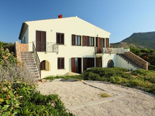 uma grande casa branca com escadas numa colina em Apartment Limette 2 by Interhome em Valledoria